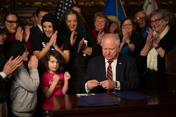 Gov. Tim Walz was applauded after he signed the final copy of the federal tax conformity bill Thursday in the reception room at the State Capitol. Amo