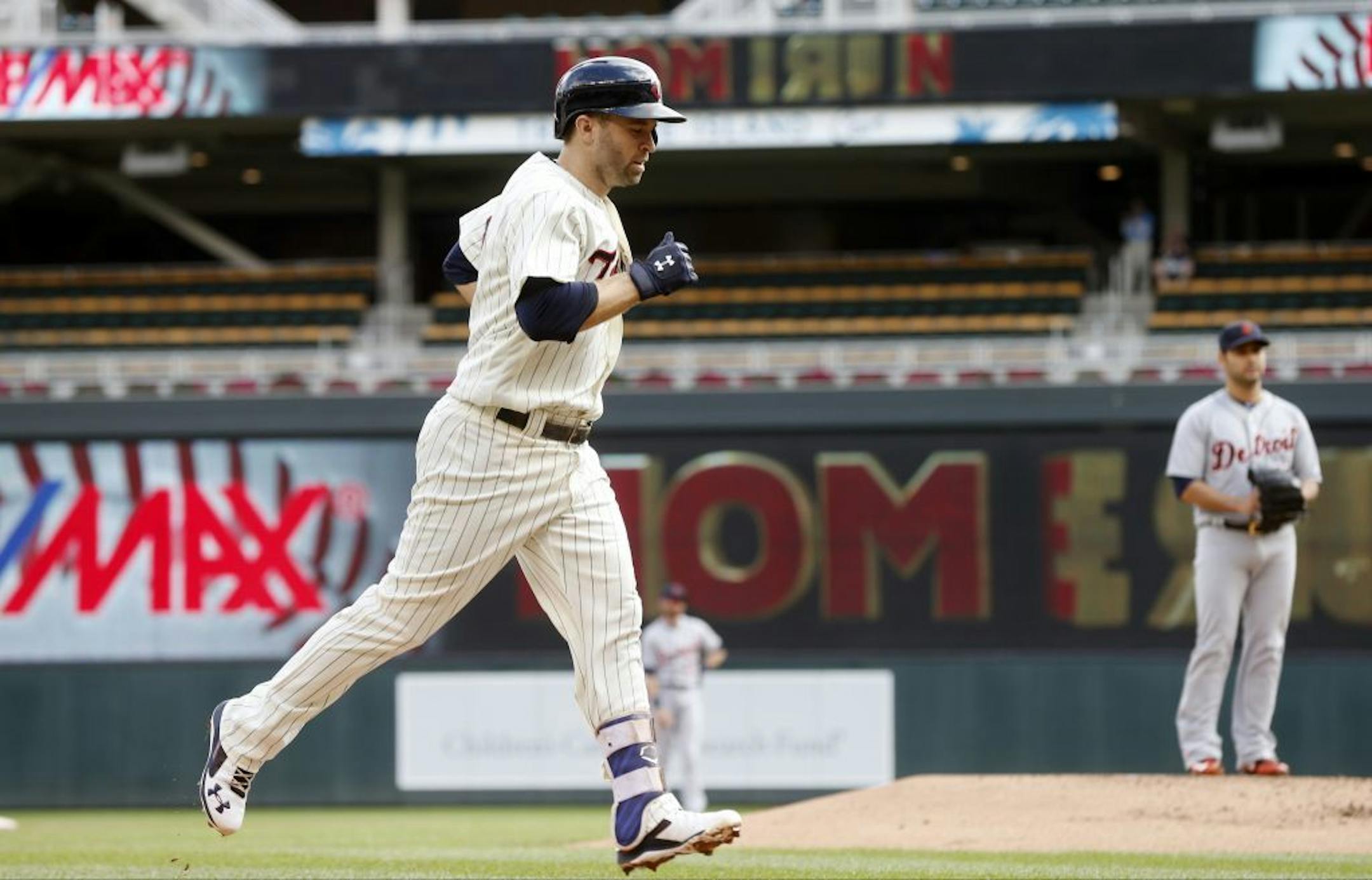 Minnesota Twins' Brian Dozier jogs home after hitting a solo home run off Detroit Tigers pitcher Anibal Sanchez, right, during the first inning in the first game of a baseball doubleheader Thursday, Sept. 22, 2016, in Minneapolis. It was Dozier's 42nd home run of the season.
