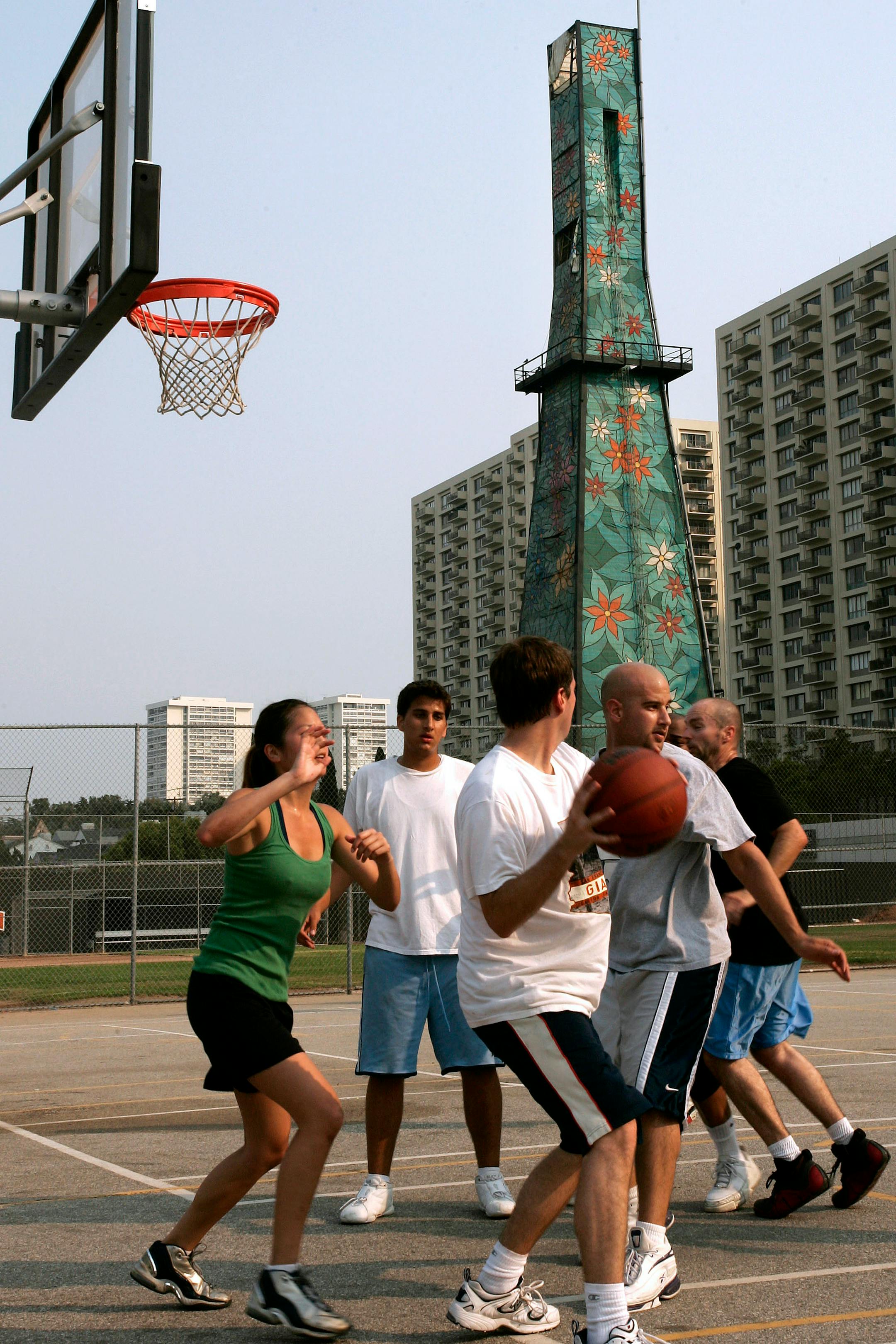 A group played basketball near a painted tower concealing an oil drill next to Beverly Hills High School. With crude oil topping $140 a barrel this year, California has issued 18 percent more permits for new drilling over the same period last year.