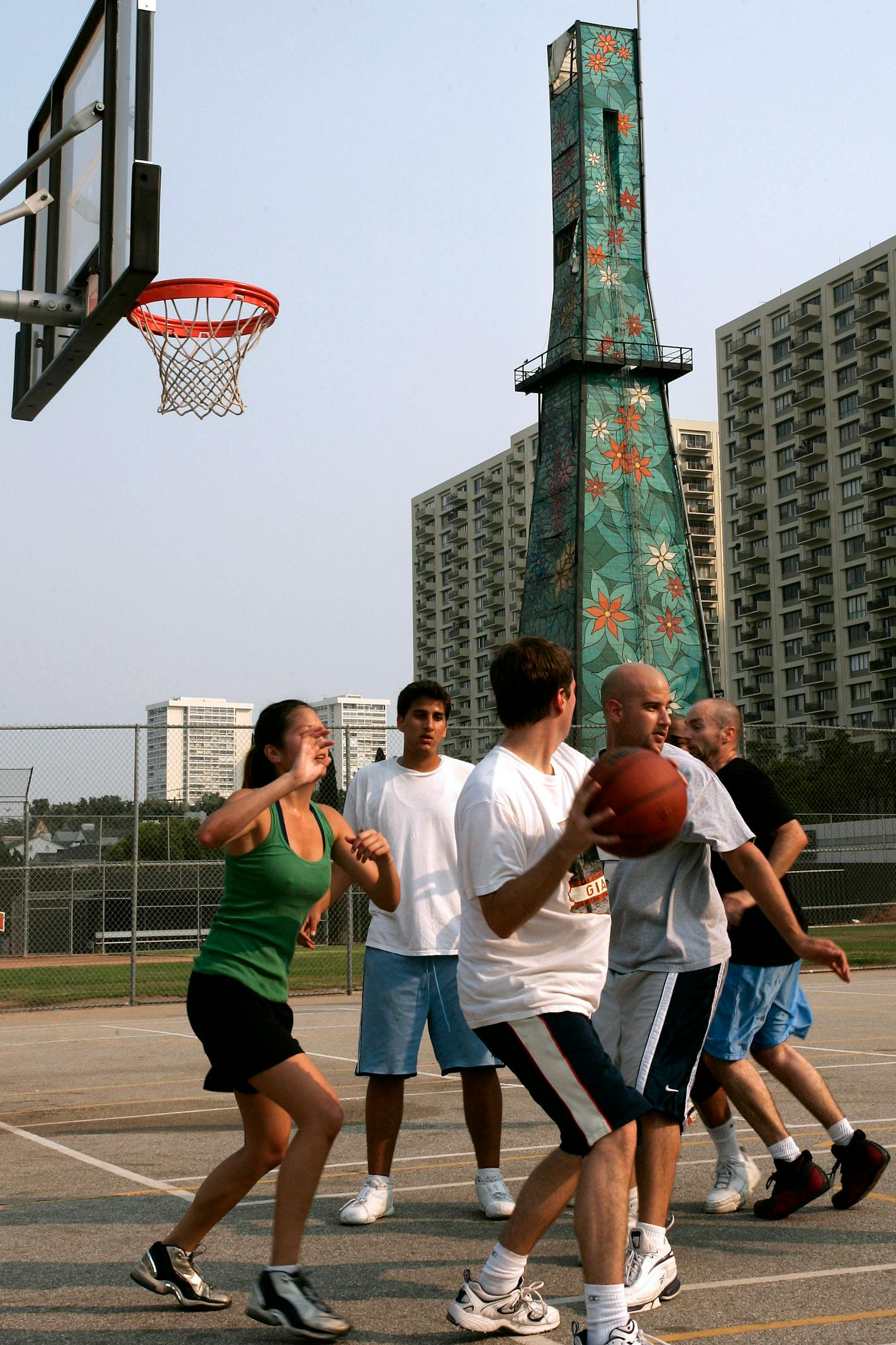 A group played basketball near a painted tower concealing an oil drill next to Beverly Hills High School. With crude oil topping $140 a barrel this year, California has issued 18 percent more permits for new drilling over the same period last year.