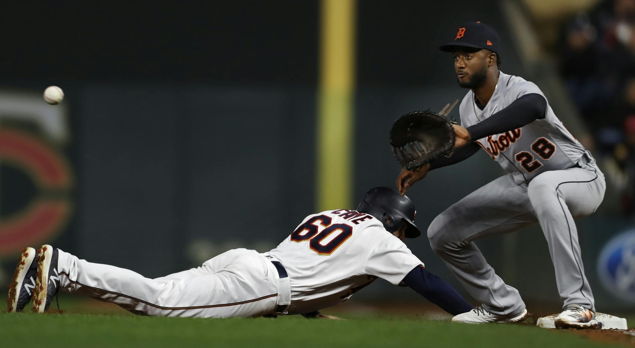 Twins Jake Cave(60) gets back to 1st baseman as Niko Goodrum(28) checks him .