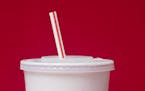 FILE- In this May 24, 2018, file photo, a large soft drink with a plastic straw from a McDonald's restaurant is shown in Surfside, Fla. McDonald's sai