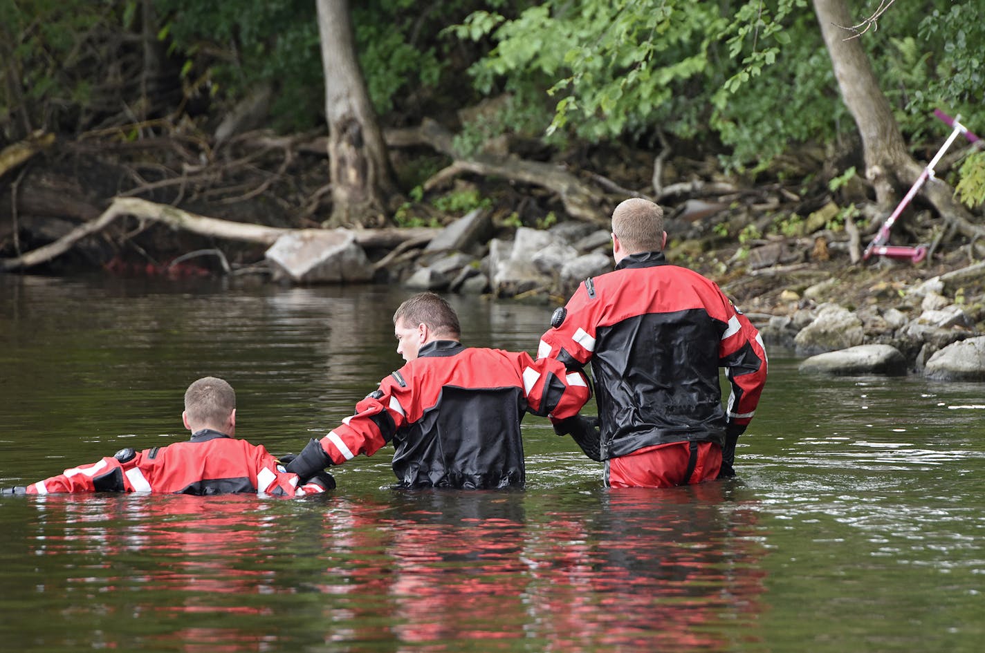 Sheriff's department dive team members join arms while conducting a search for 6-year-old Hamza Elmi Friday, July 24, 2015, near the location where his scooter was found on the banks of the Mississippi River in St. Cloud, Minn. His body was recovered in the river Friday. (Dave Schwarz /St. Cloud Times via AP) NO SALES; MANDATORY CREDIT ORG XMIT: MIN2015072413554542