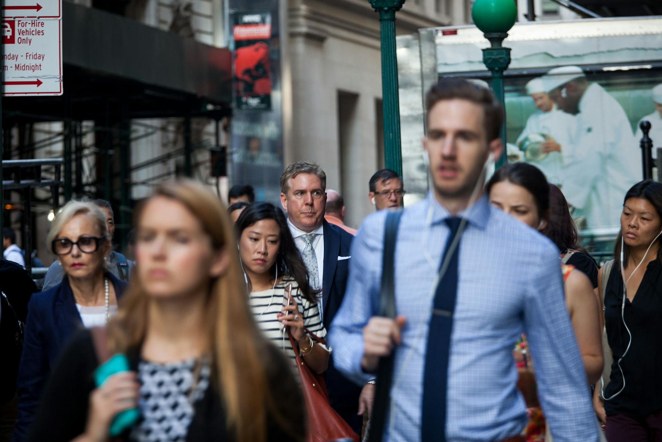 Pedestrians walk along Wall Street in New York on Aug. 15, 2016. MUST CREDIT: Bloomberg photo by Michael Nagle.