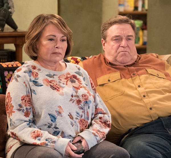 FILE - In this image released by ABC, Roseanne Barr, left, and John Goodman appear in a scene from the reboot of "Roseanne." The Nielsen company said 