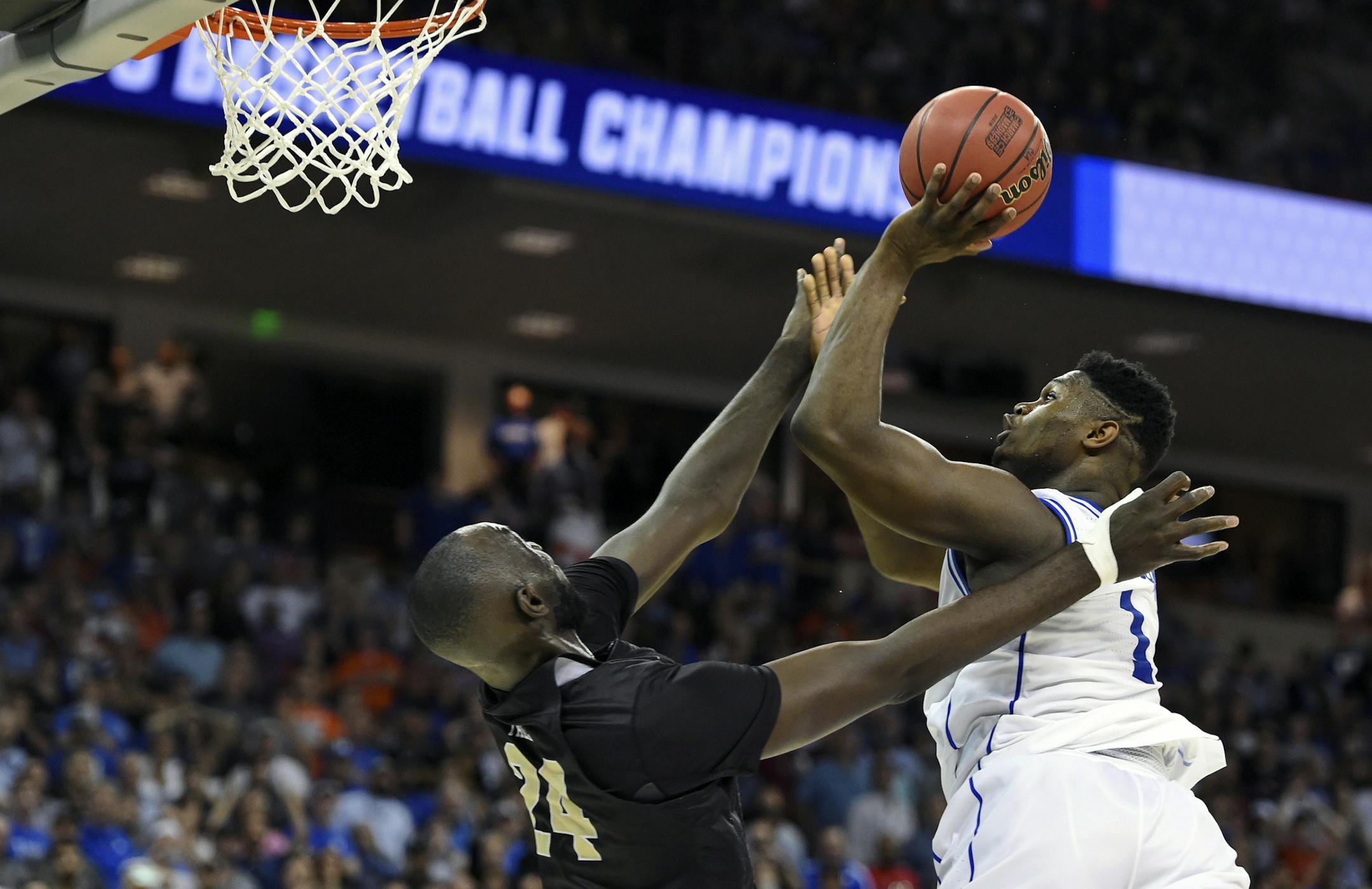Duke's Zion Williamson, right, shoots over Central Florida's Tacko Fall during the second half of a second-round men's college basketball game in the NCAA Tournament in Columbia, S.C., Sunday, March 24, 2019. (AP Photo/Richard Shiro)