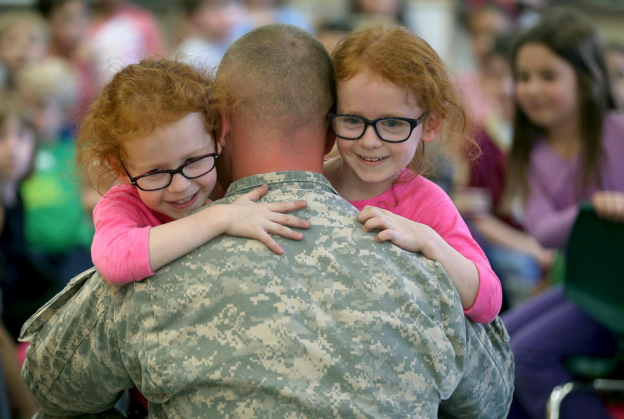 Hale Elementary School kindergarten twins Kaylee, left, and Ariana Martinez received a big hug from their father Jacob Martinez after surprising them in class, Monday, April 27, 2015 in Minneapolis, MN. Martinez returned after a year in Kuwait and Iraq. ] (ELIZABETH FLORES/STAR TRIBUNE) ELIZABETH FLORES • eflores@startribune.com