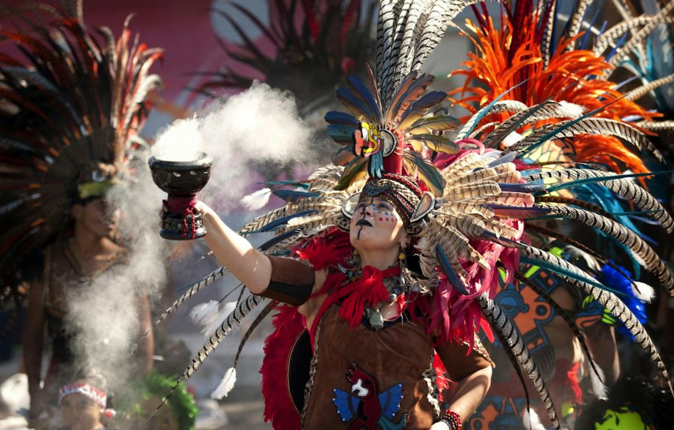 Nereida Flores of Ketzal Coatlicue Aztec Dance Troupe held up a smoking pot of copal. The incense is used to protect, clear negative energy and energize those present. El Colegio charter high school dedicated a patio area Friday, August 17, 2012 that has a sophisticated stormwater retention system. The soccer field, garden and outdoor seating area replaces a blighted old parking lot.