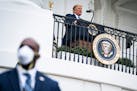 A Secret Service agent stands guard as then-President Donald Trump speaks to supporters from a White House balcony on Oct. 10 after testing positive f