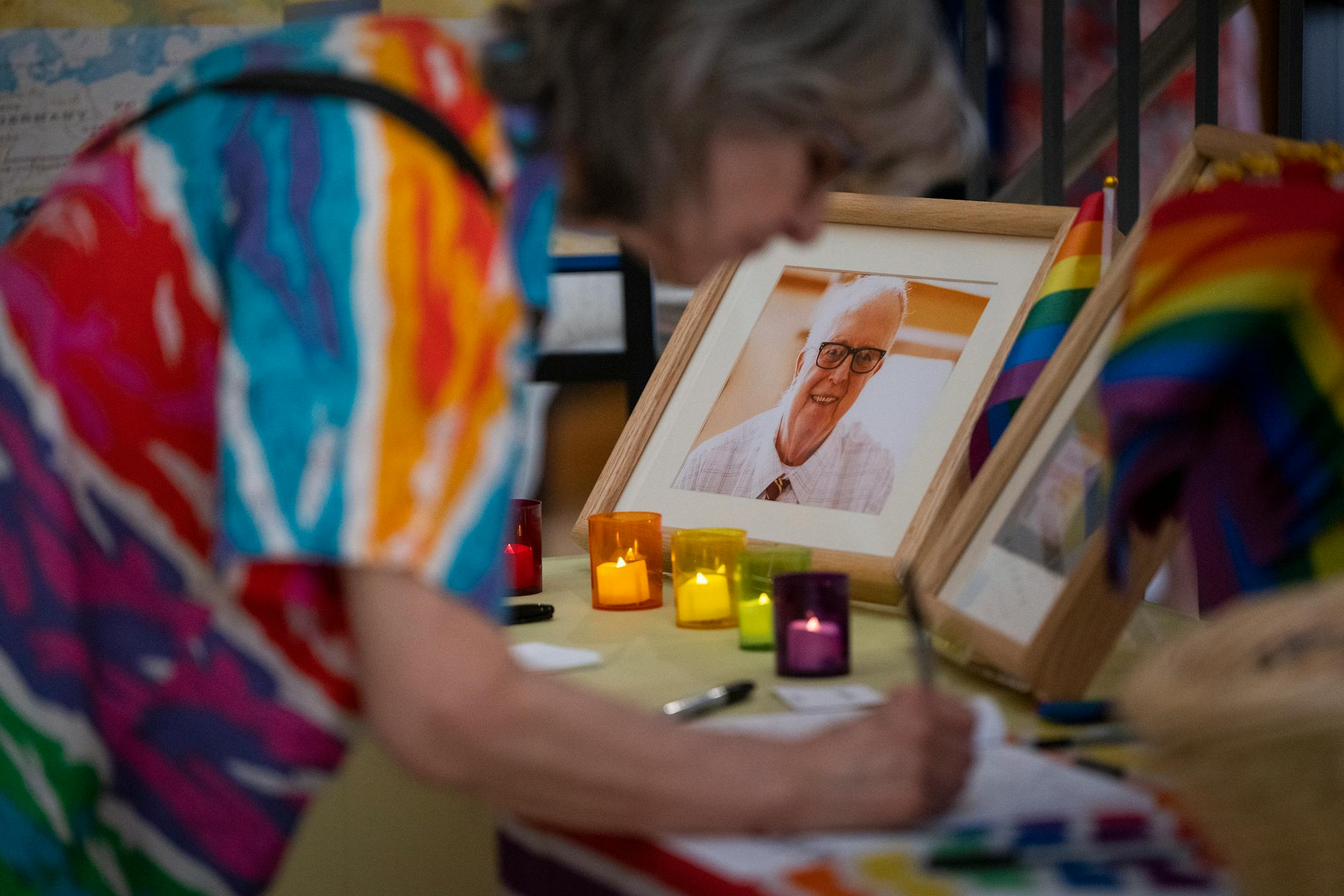 Guests sign a guest book as a photo of Jean-Nickolaus Tretter is displayed during the celebration of life for Jean-Nickolaus Tretter at the Elmer L. Andersen Library.