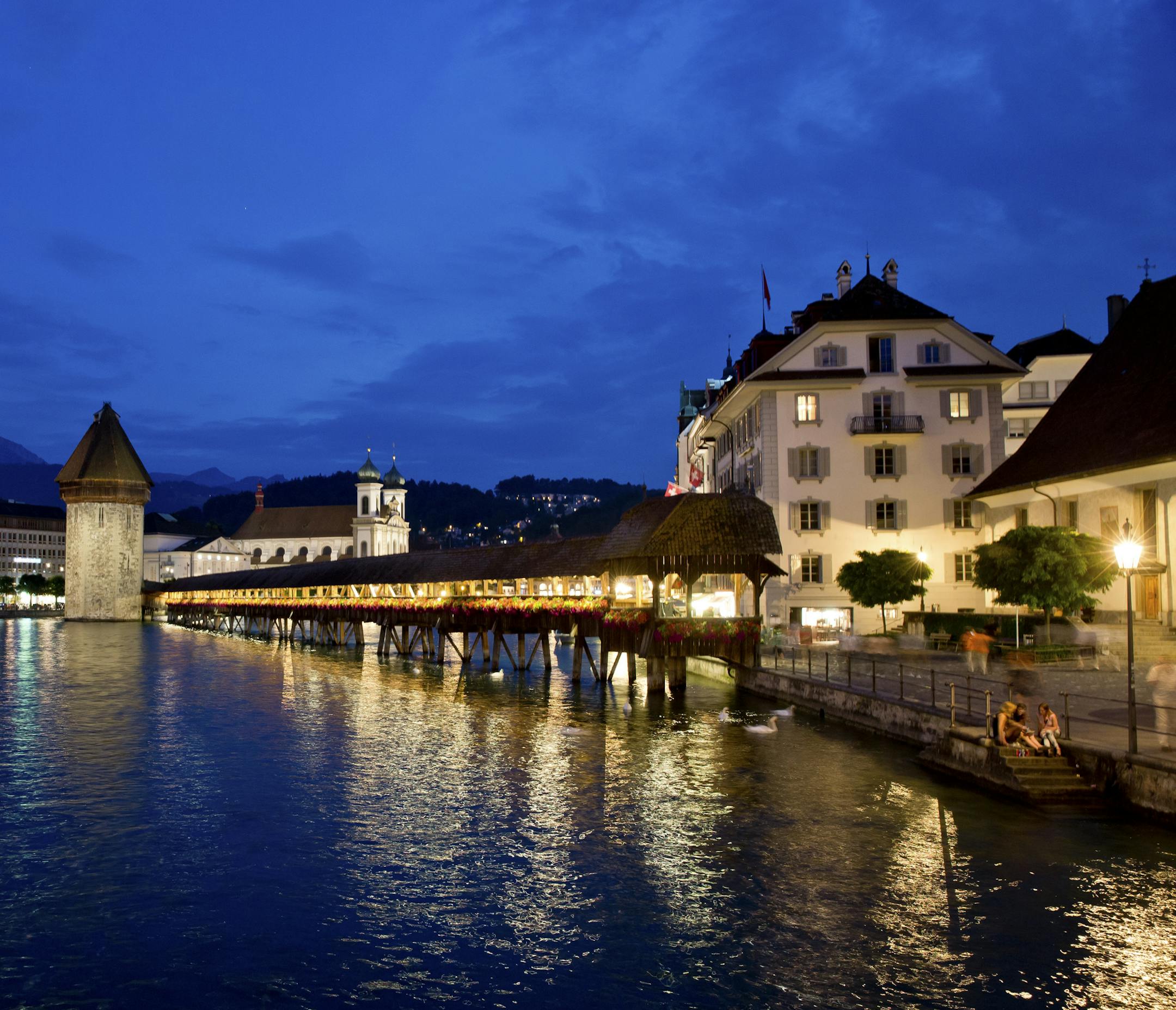 The Chapel Bridge with the Water Tower at the river Reuss in the centre of Lucerne, Switzerland, 19 July 2013. In the back is the Jesuit Church. Photo by: Daniel Karmann/picture-alliance/dpa/AP Images