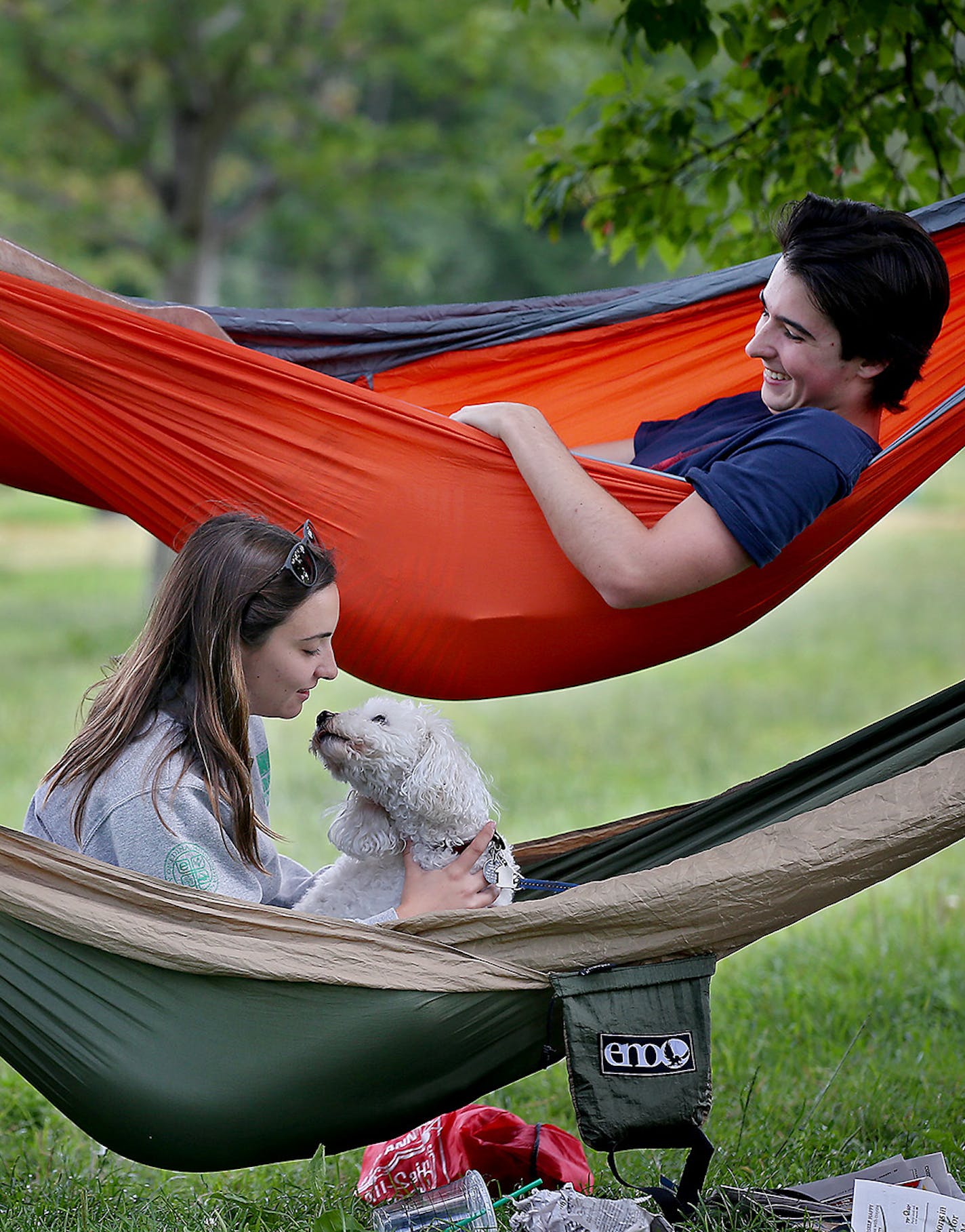 Grace Johnson, left, and Max Gibbs relaxed with Johnson&#x2019;s dog, Wally, as they connected their hammocks to a couple of trees along Lake Calhoun.