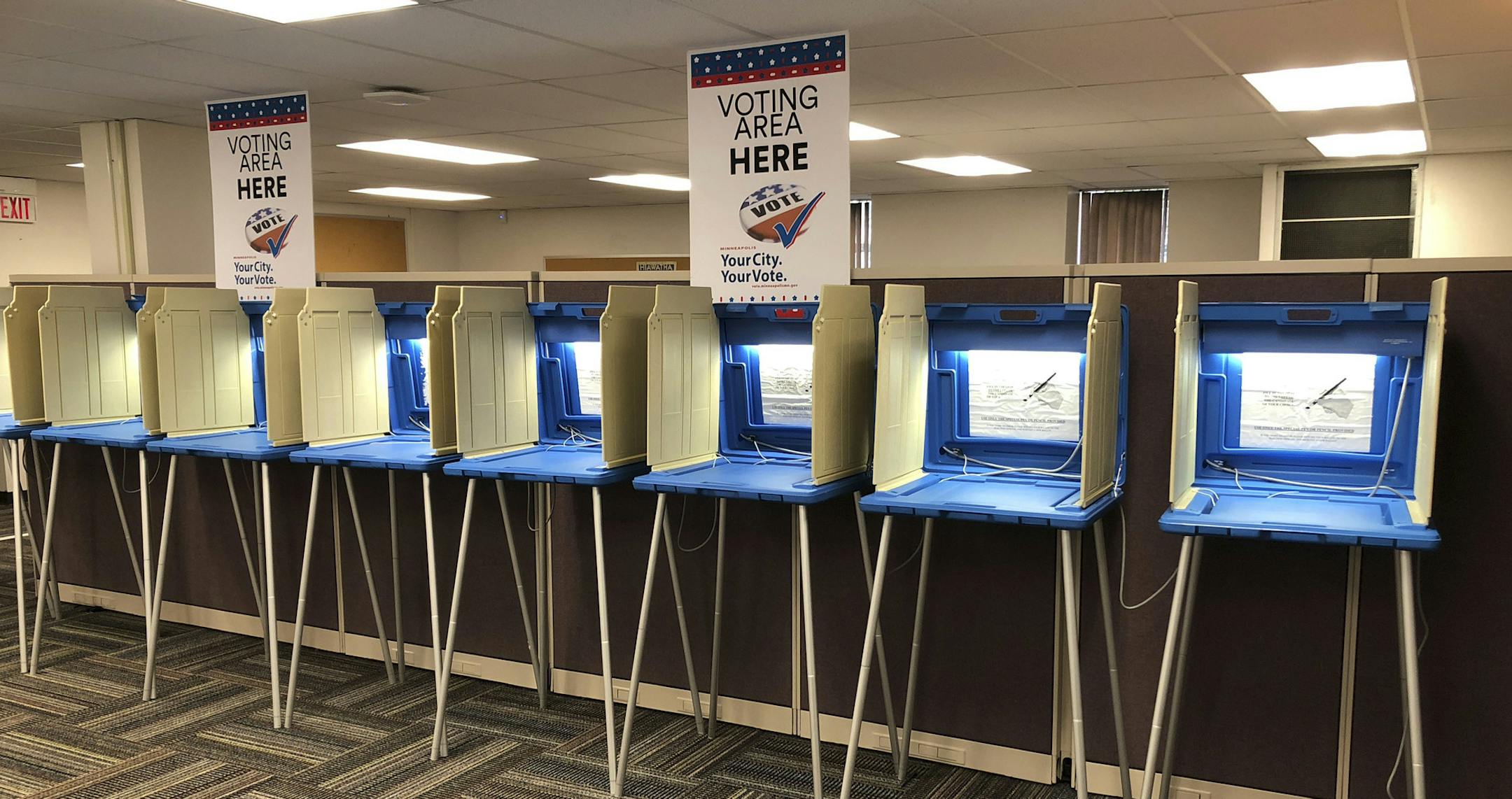 In this Sept. 20, 2018 photo, voting booths stand ready in downtown Minneapolis for the opening of early voting in Minnesota. Election officials and federal cybersecurity agents are touting improved collaboration aimed at confronting and deterring efforts to tamper with elections. Granted, the only way to go was up: In 2016 amid Russian meddling, federal officials were accused first of being too tight-lipped on intelligence about possible hacking into state systems, and later criticized for tryi