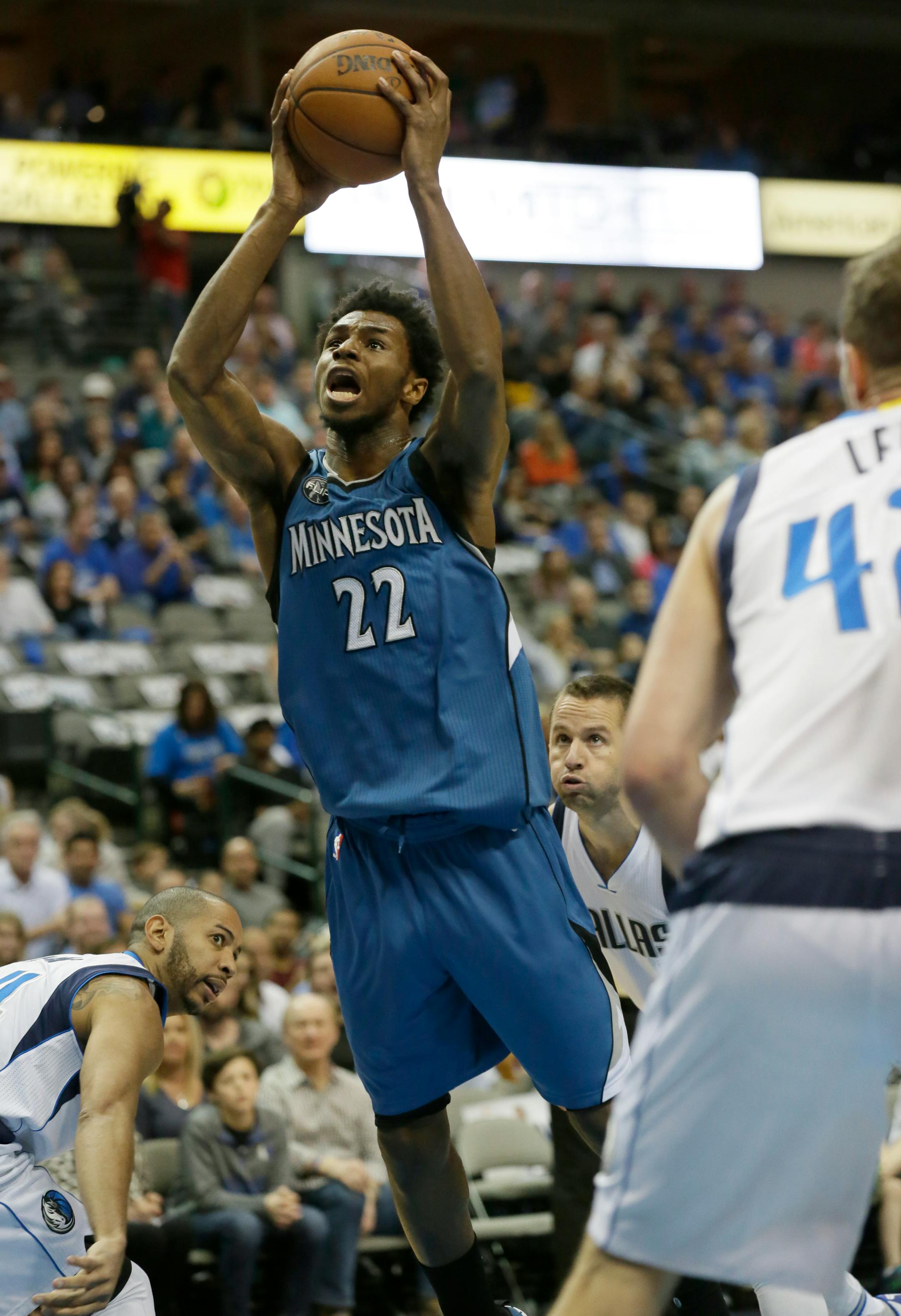 Minnesota Timberwolves guard Andrew Wiggins (22) shoots against Dallas Mavericks defenders Devin Harris, left, J.J. Barea (5) and David Lee (42) during the first half of an NBA basketball game Sunday, Feb. 28, 2016, in Dallas. (AP Photo/LM Otero)