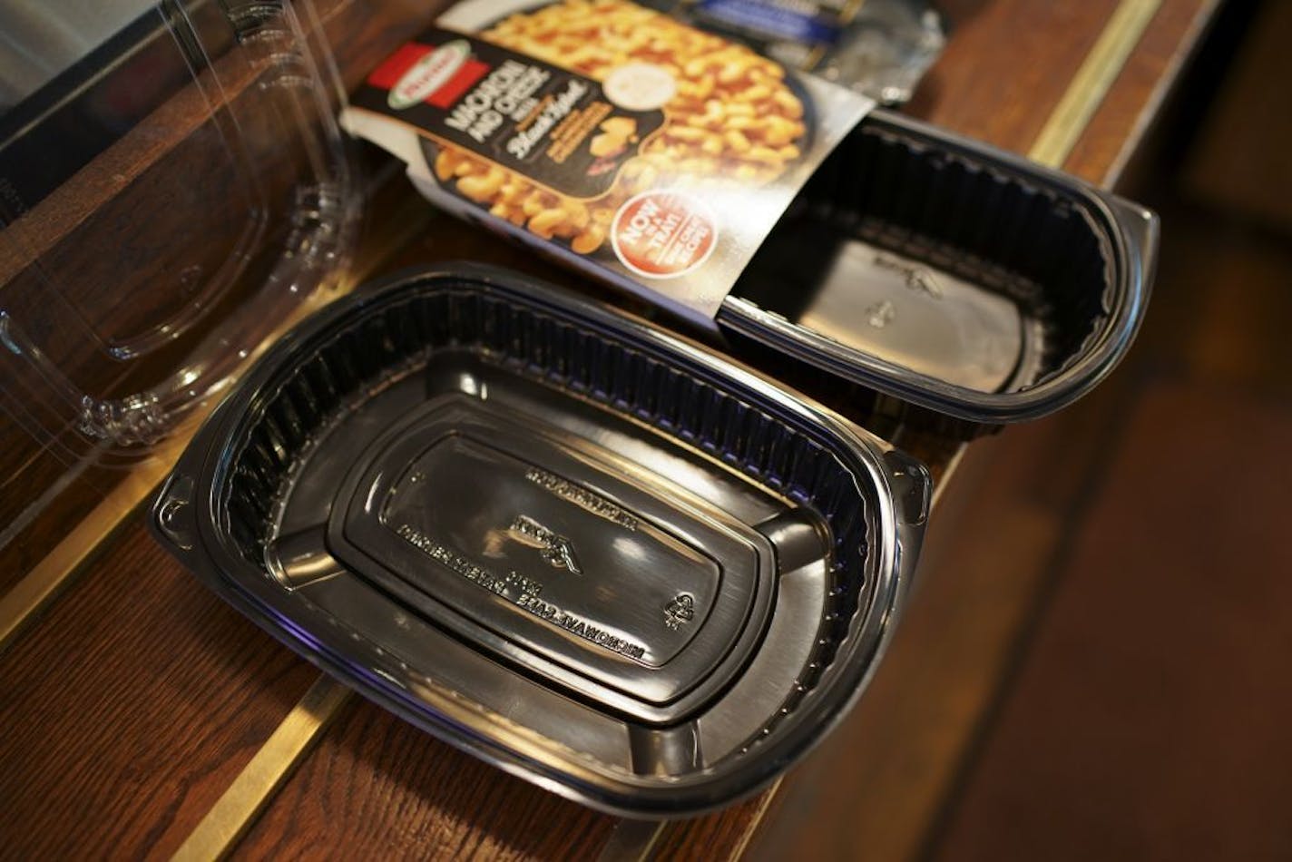 A food container used by Cossetta, foreground, and a container made by the same company and used by Hormel to package food for sale in grocery stores. Both carry the recyclable symbol.