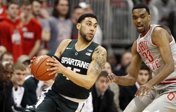 Michigan State's Denzel Valentine, left, works against Ohio State's Keita Bates-Diop during an NCAA college basketball game in Columbus, Ohio, Wednesd
