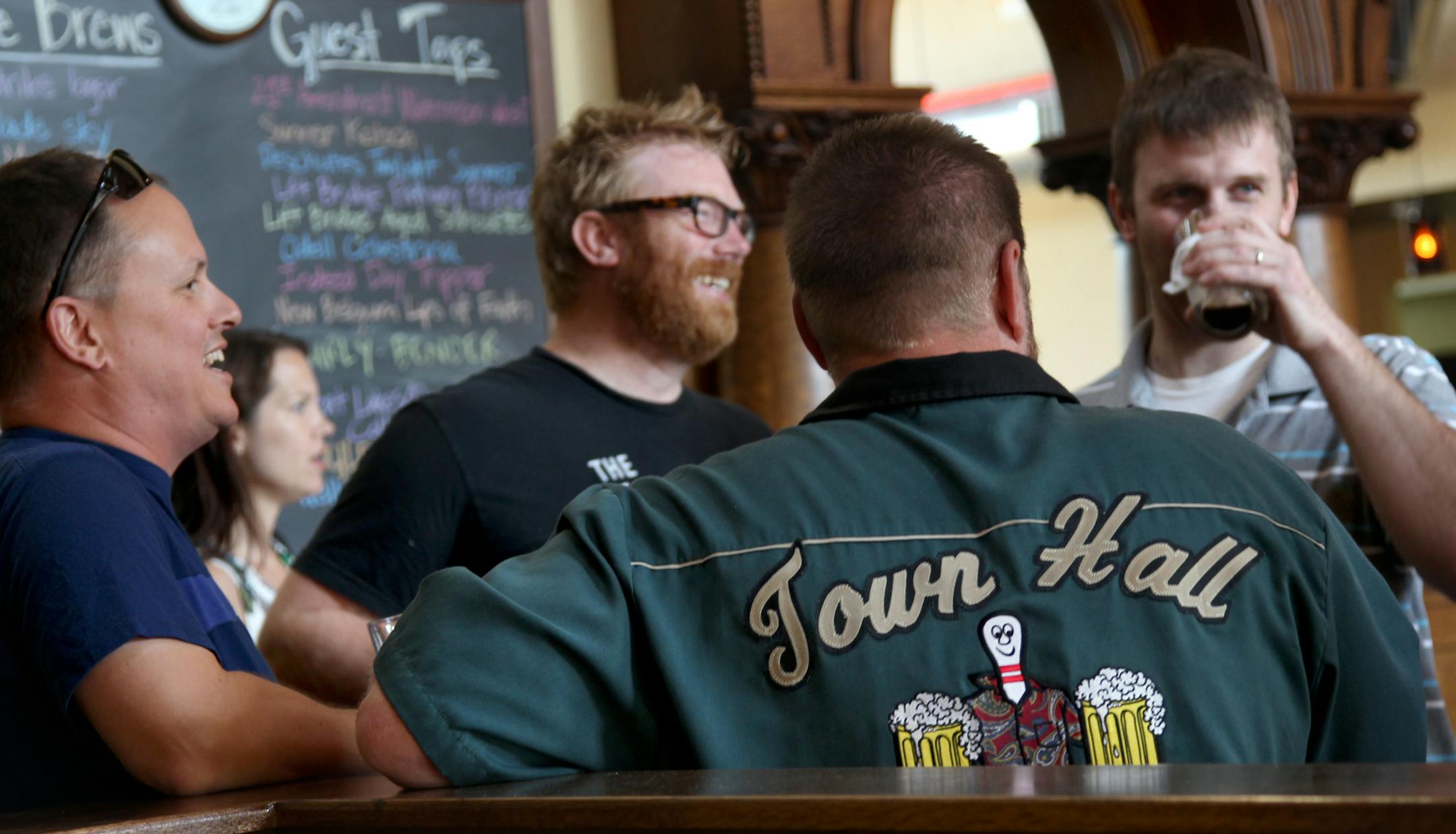 Back to camera, Tall Hall Brewer Mike Hoops chats with patrons at the opening of the Town Hall Lanes. The opening day of the Town Hall Lanes, bowling alley on 34th and 50th in the Nokomis neighborhood is a great new spot. ] STAR TRIBUNE/TOM WALLACE Assignments #20029983A July 19, 2013 SLUG & MAGIC SAXO#: 676377 BARS072613 EXTRA INFO: 676377 Beloved Minneapolis brewpub Town Hall Brewery is expanding again. Unlike any brewpub or taproom in town, the new Town Hall Lanes offers bowling, having renov