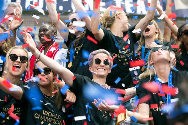 Megan Rapinoe, center, is joined by teammates on the U.S. women's national soccer team during a celebratory rally at City Hall following a ticker-tape