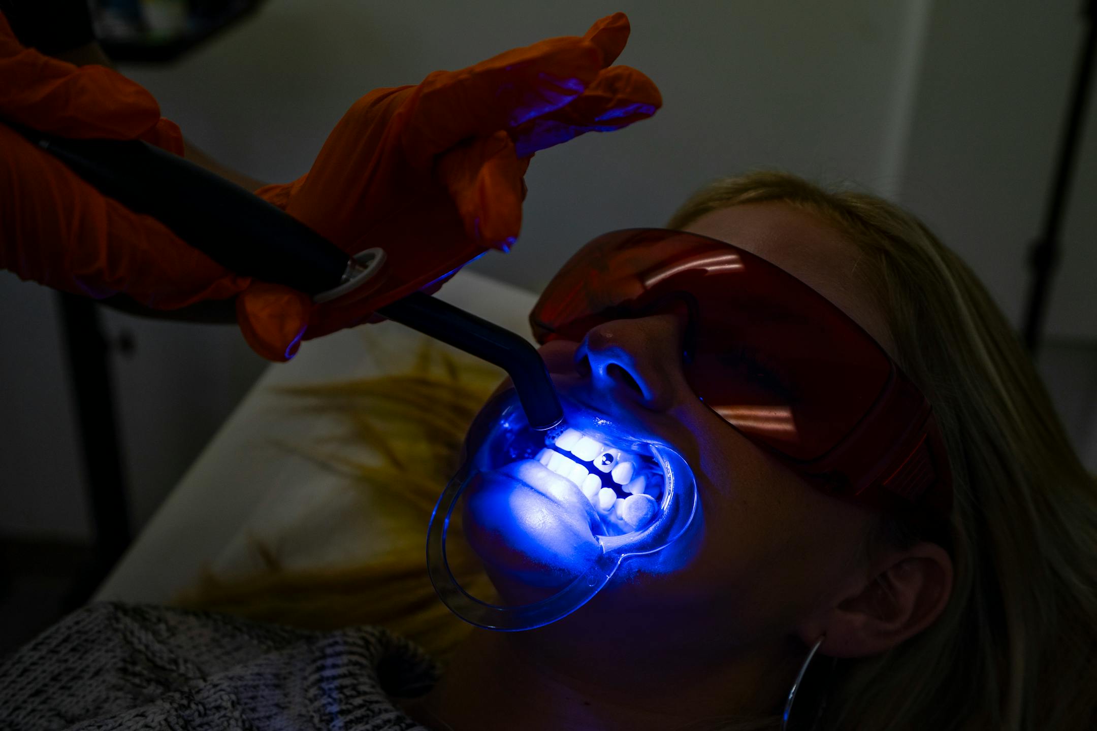 Mirna Lovo, owner of Pearly Whites MN, applies tooth gems to Josie Wicka, one of her most frequent clients, in Burnsville, Minn. on Thursday, June 29, 2023.