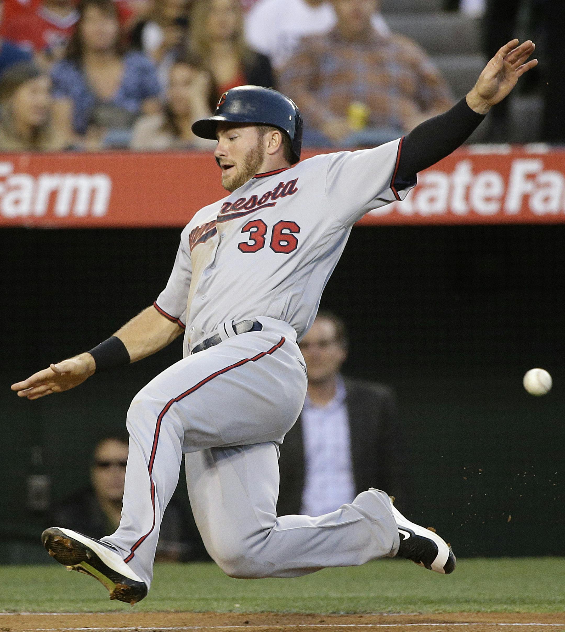 Minnesota Twins' Robbie Grossman slides into home plate to score on a single by Trevor Plouffe during the third inning of a baseball game against the Los Angeles Angels, Tuesday, June 14, 2016, in Anaheim, Calif. (AP Photo/Jae C. Hong)