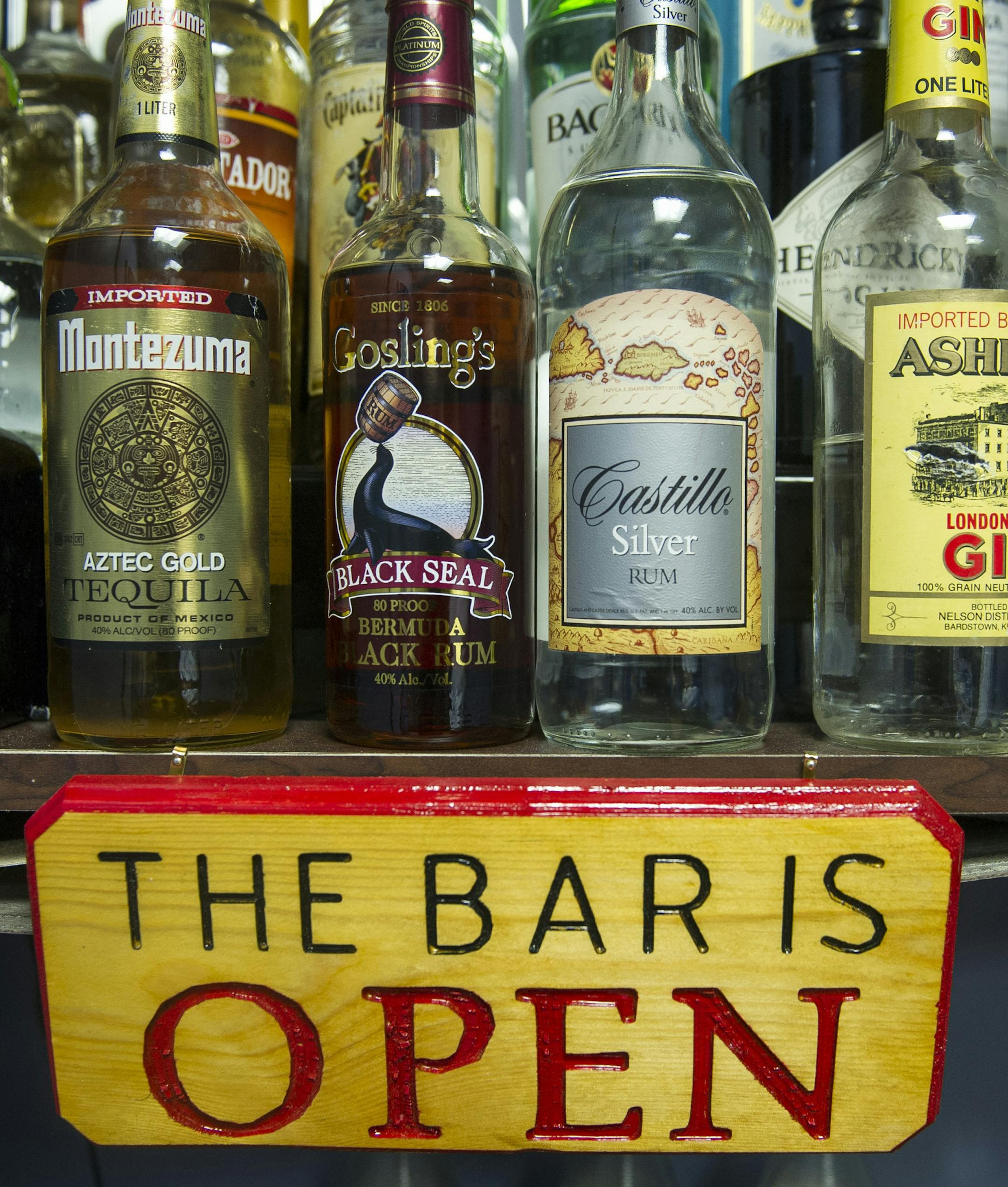 In this Dec. 19, 2014 photo, alcohol bottles, their contents replaced with colored water, sit on a shelf in the National Institute on Alcohol Abuse and Alcoholism's research alcohol bar at National Institutes of Heath in Bethesda, Md. Inside the hospital at the National Institutes of Health, researchers are testing a possible new treatment to help heavy drinkers cut back, by using a replica of a fully stocked bar. (AP Photo/Cliff Owen)