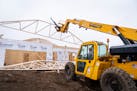 In this March 2020 file photo, workers build a new home at a construction site in Woodbury, where population growth is main reason behind the South Wa