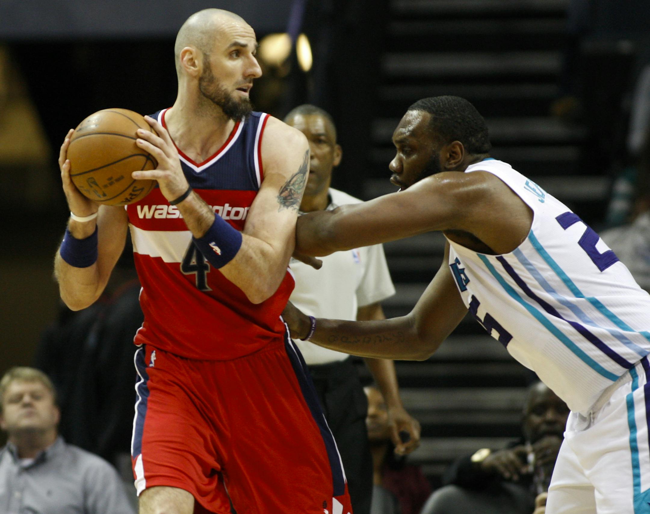 Washington Wizards center Marcin Gortat, left, of Poland, looks to pass against Charlotte Hornets center Al Jefferson in the first half of an NBA basketball game Monday, March 9, 2015, in Charlotte, N.C. The Wizards won 95-69. (AP Photo/Nell Redmond)