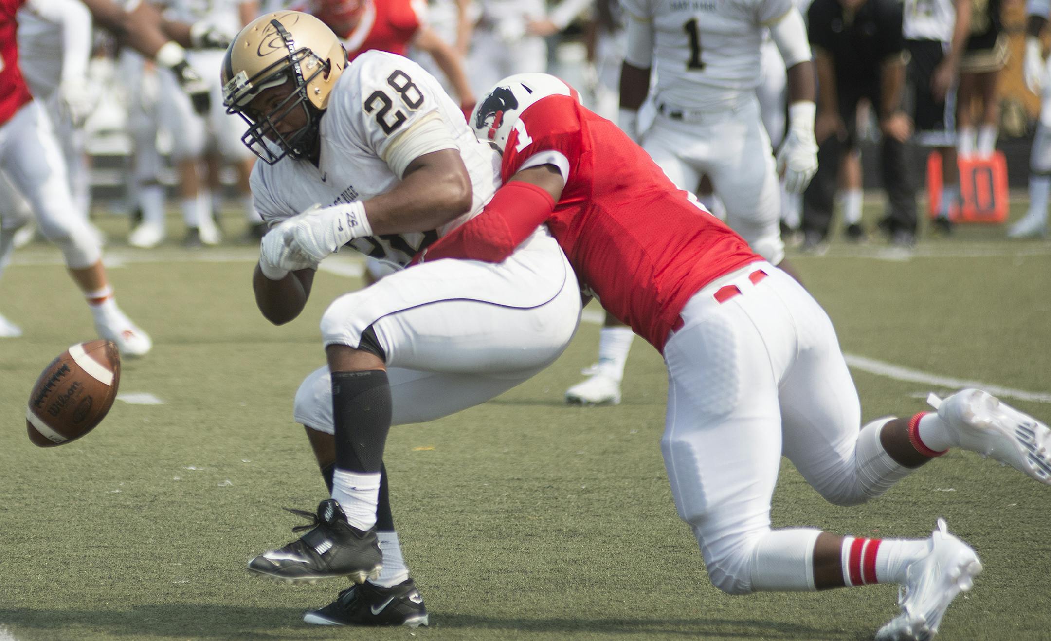 A direct hit from Lakeville North's Jacob Traefald causes East Ridge High School's Dominik London to drop a pass caught seconds before off a throw from East Ridge quarterback, Otumus Payemnu. (Matthew Hintz, 082215, Lakeville)