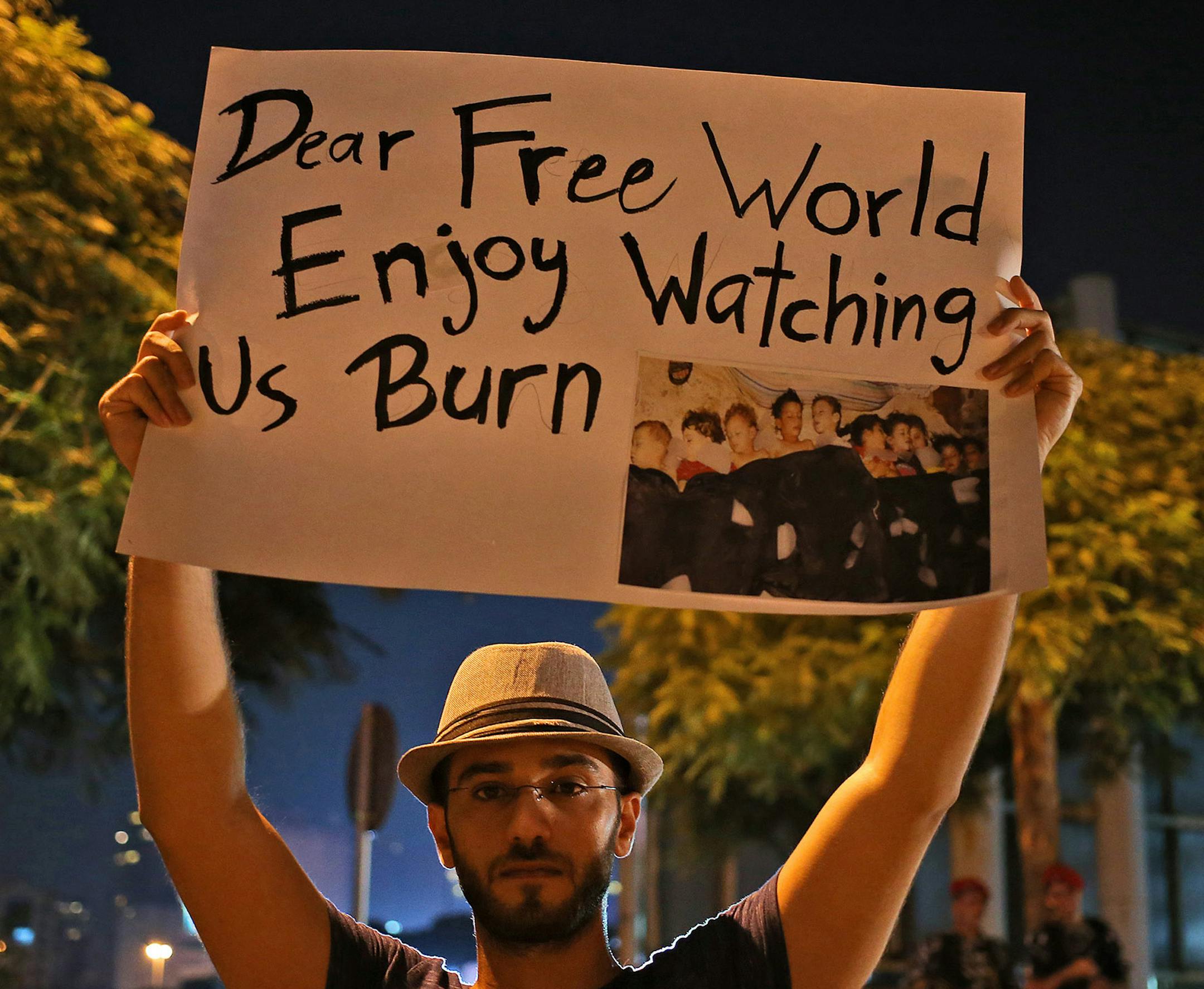 A Syrian man who lives in Beirut, Lebanon, held a placard during a vigil against the alleged chemical weapons attack on the suburbs of Damascus.
