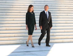 U.S. Supreme Court Associate Justice Amy Coney Barrett, left, and Chief Justice John Roberts walk down the steps of the west side of the Supreme Court