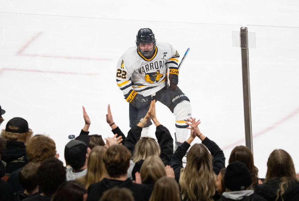 Warroad forward Murray Marvin-Cordes celebrates with fans after scoring a goal against New Ulm during the third period Wednesday.