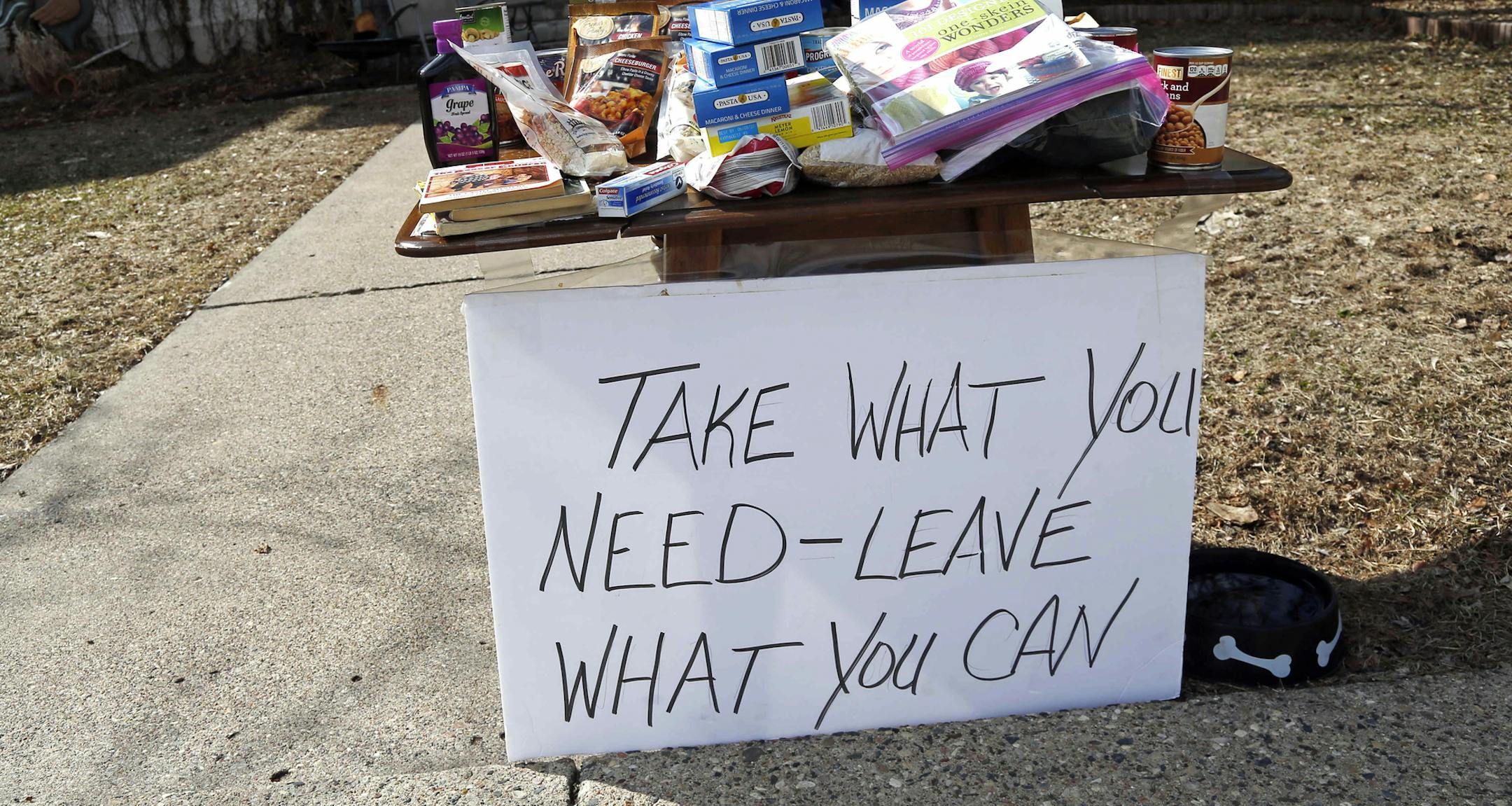 Food for the taking and an invitation to leave food is in front of a south Minneapolis home Monday, March 23, 2020 as Minnesotans care for others during the effort to slow down the coronavirus in the state. (AP Photo/Jim Mone)
