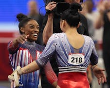 Simone Biles is embraced by Suni Lee on Day 2 of the United States women's gymnastics Olympic trials at Target Center on Sunday. Biles finished first 