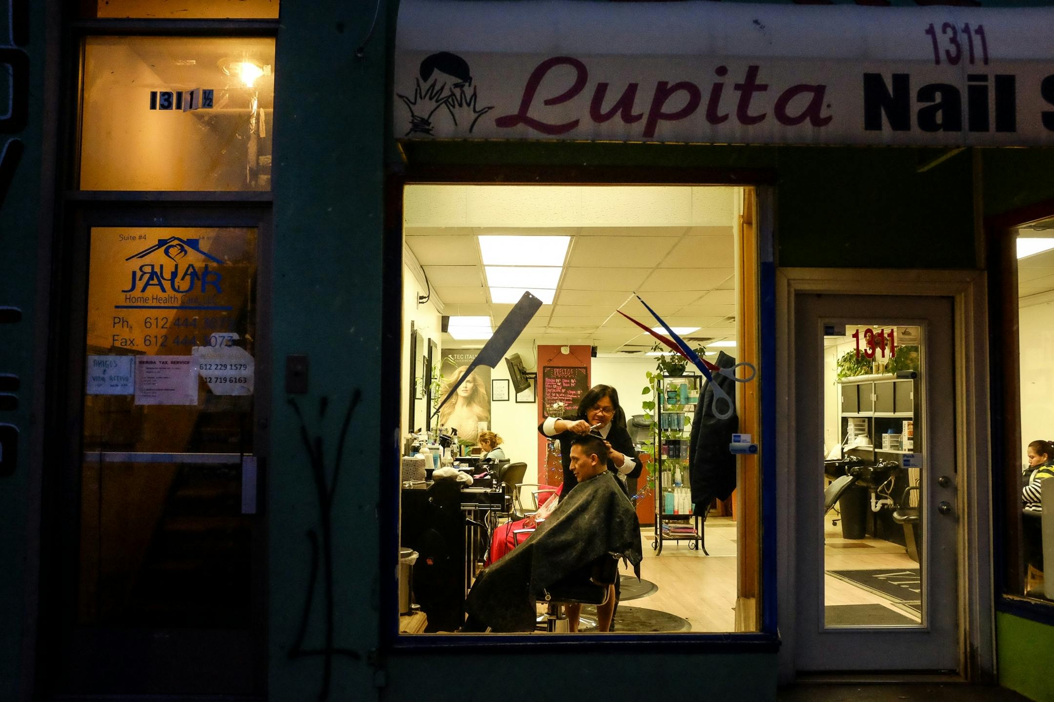 Luz Torres, a hair stylist at Lupita Nail Salon on East Lake Street, cut the hair of a client who did not with to be identified, Friday night in the Powderhorn neighborhood.