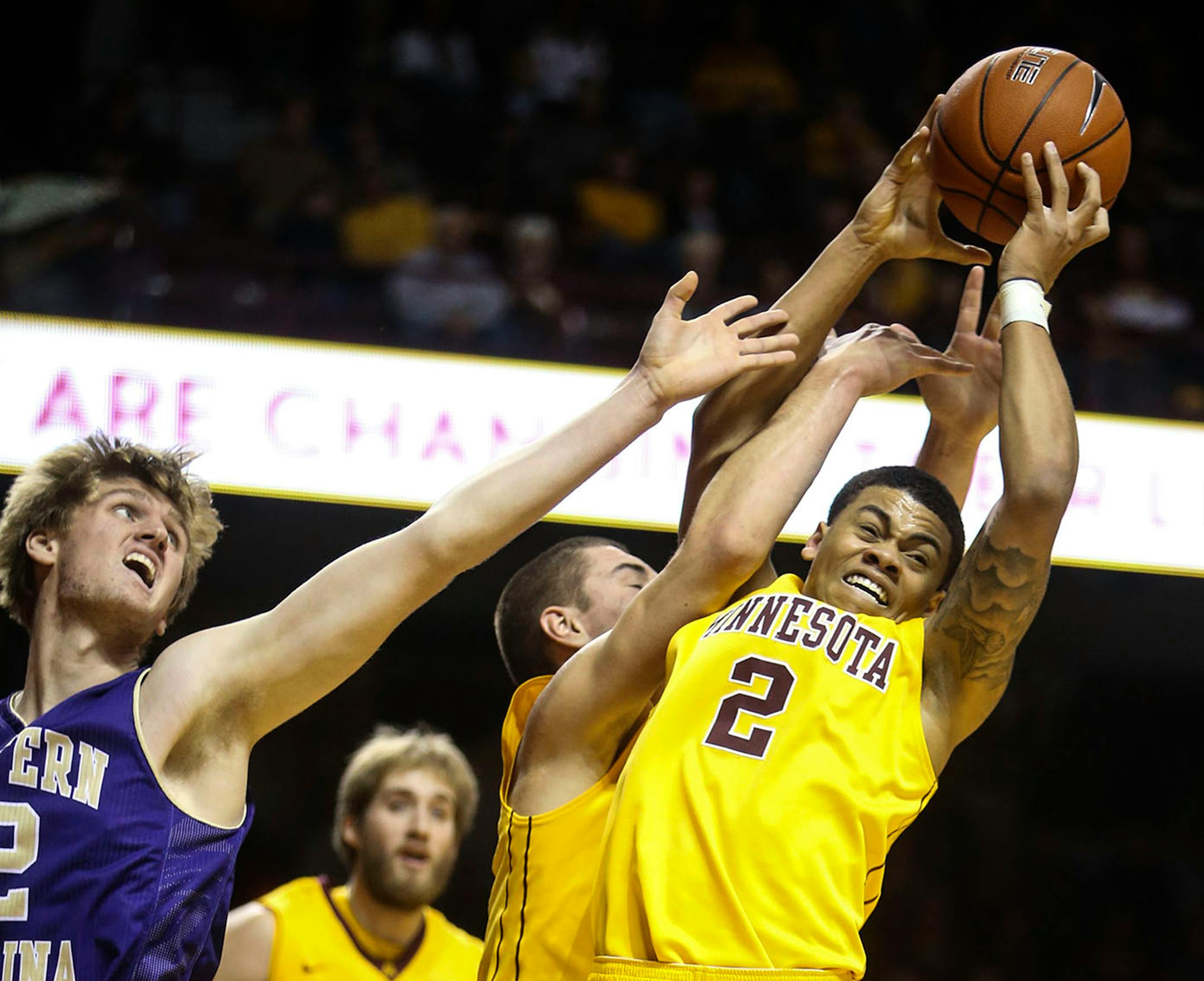 Nate Mason (2) goes high for a rebound over Western Carolina's Tucker Thompson (12) during the first half Friday Dec. 5, 2014, at Williams Arena on the University of Minnesota campus in Minneapolis, MN.