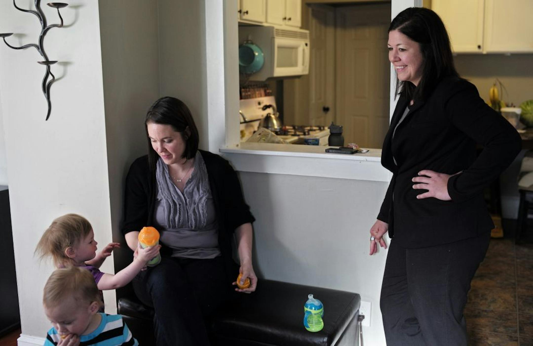 At their small home in North Minneapolis, Annie Hansen-Burke with her partner, children Leo and Josephine moving out to a bigger home in Robinsdale. Because of their income, they are unable to purchase homes are that are income restricted. On the right is real estate consultant Angie Sherer.