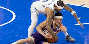 Nickeil Alexander-Walker of the Wolves thwarts Devin Booker of the Suns on Tuesday night at Target Center.