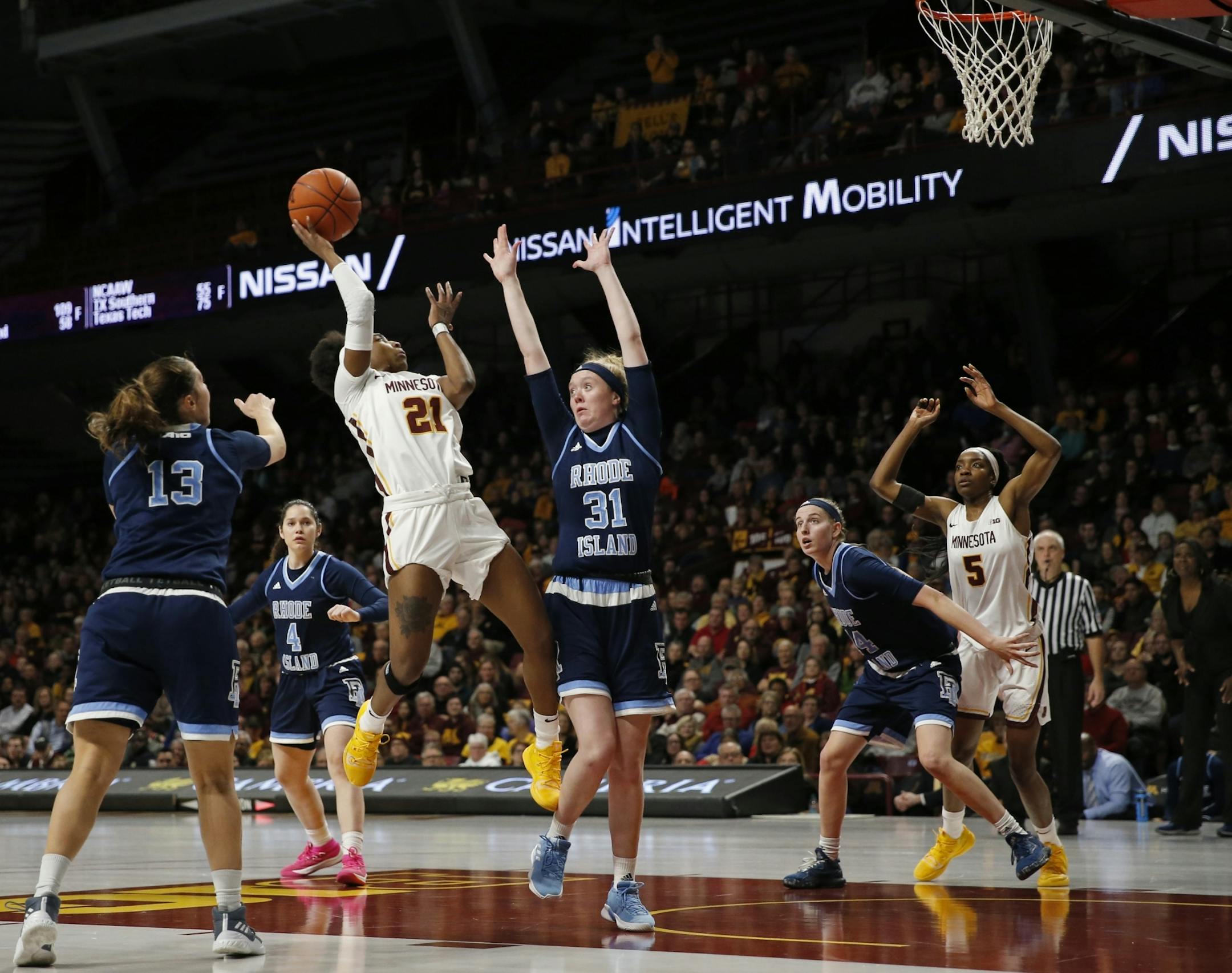 Minnesota Gophers guard Jasmine Brunson (21) was challenged on a layup attempt by Rhode Island defenders Marta Vargas (13) and Abby Streeter (31) in the first half.