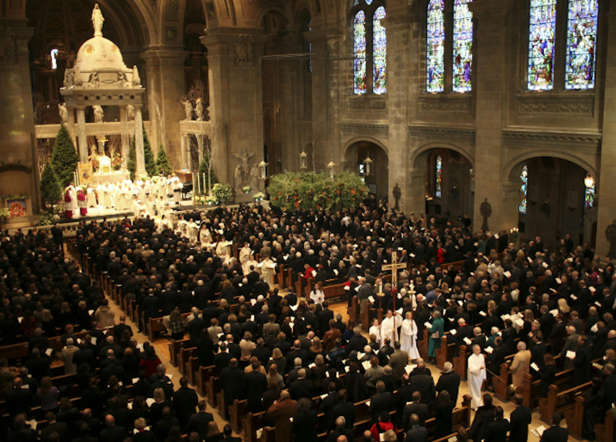 Celebrants and the choir led the procession out of the Basilica of St. Mary following Carl Pohlad's funeral mass Thursday afternoon.