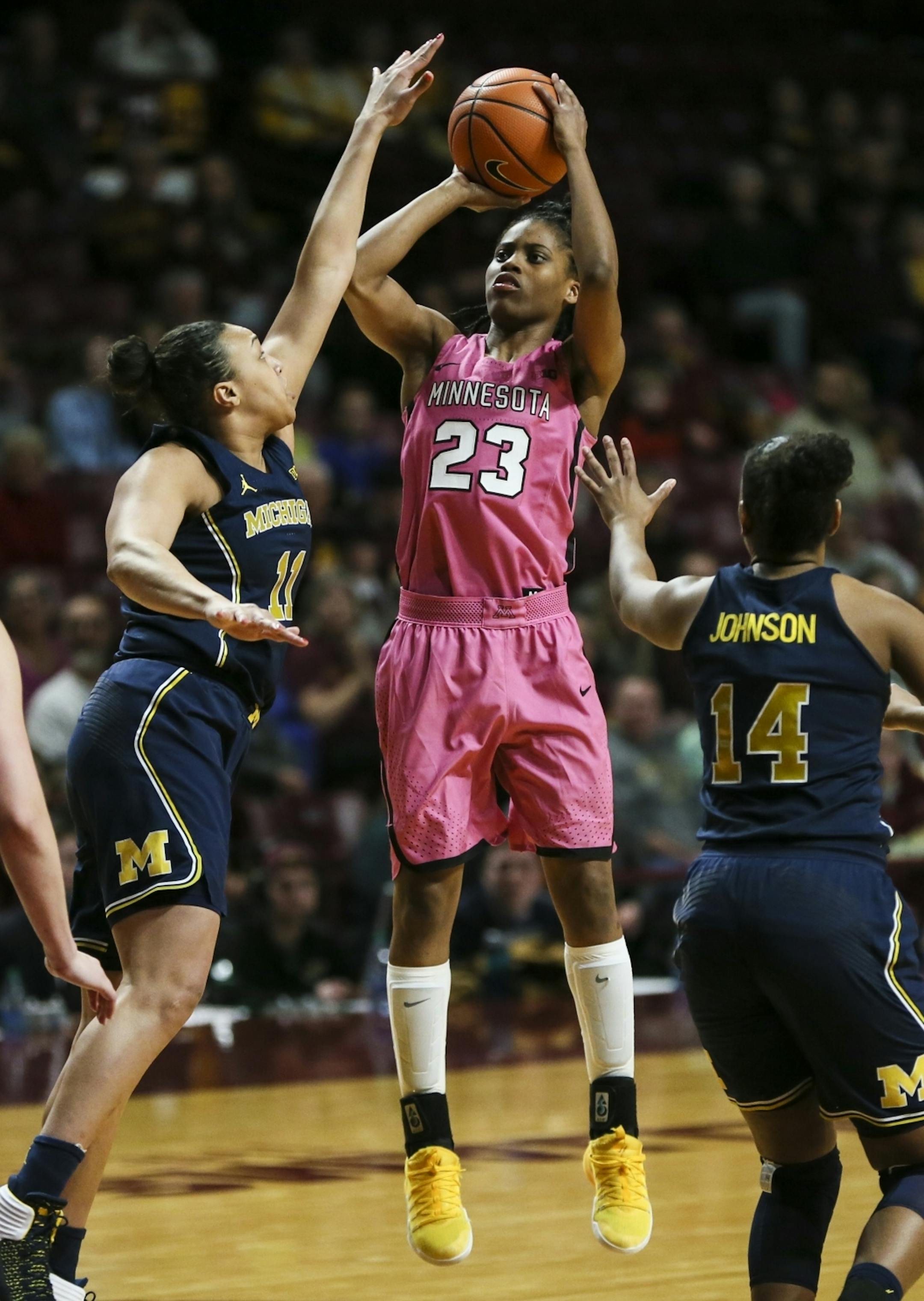 Minnesota Golden Gophers guard Kenisha Bell (23) jumped for a shot against Michigan Wolverines Jillian Dunston (11) in the first half.