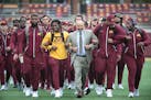 Eric Klein, center, the head strength and conditioning coach, led the team onto the field before the Gophers took on Colorado State at TCF Bank Stadiu
