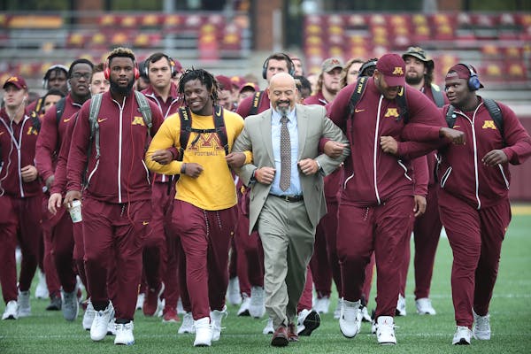 Eric Klein, center, the head strength and conditioning coach, led the team onto the field before the Gophers took on Colorado State at TCF Bank Stadiu
