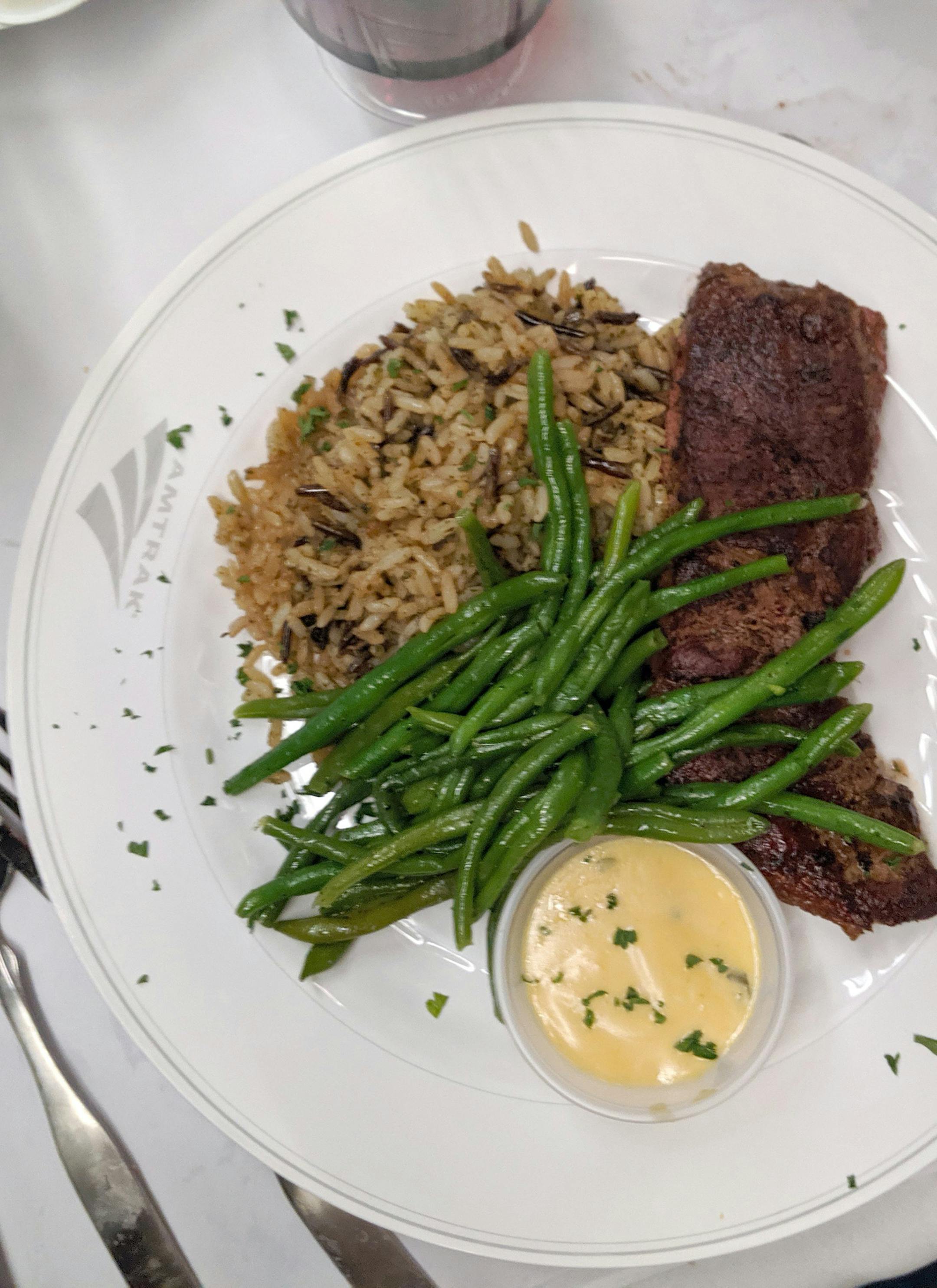 In the dining car, the Amtrak Signature Steak ($25) is grilled to order and served with bearnaise sauce, wild rice and green beans. Recommended pairing: a plastic half-bottle of cabernet sauvignon ($16). (Alexandra Marvar/Chicago Tribune/TNS) ORG XMIT: 1584048