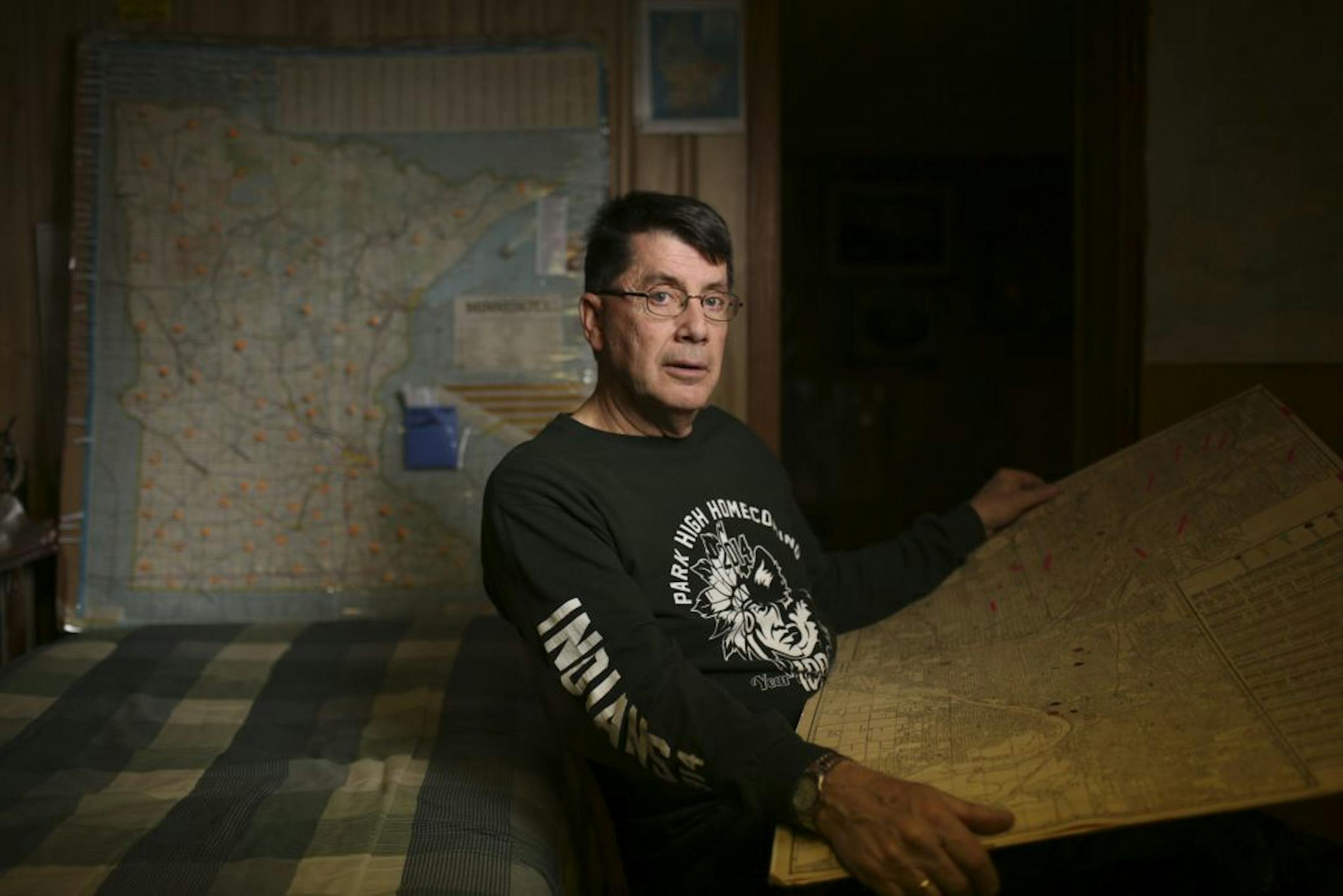 Herb Reckinger in his basement office with maps he's using for research and to keep track of pictures he's located of the relatively few remaining undocumented Vietnam era casualties .