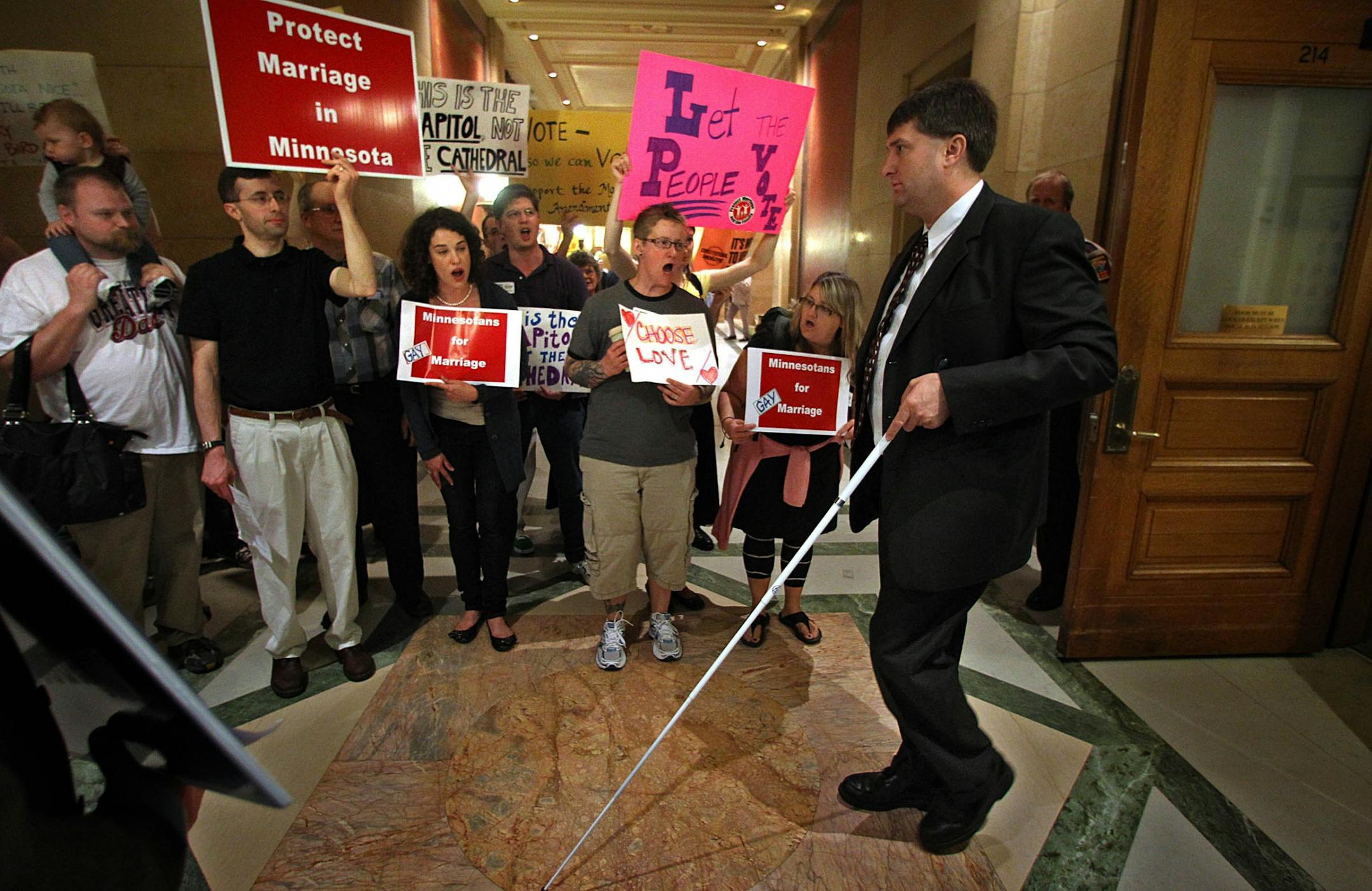 State Rep. Torrey Westrom, walked past people supporting and opposing the proposed amendment to the state Constitution banning same-sex marriage. Westrom was leaving the House Chambers during a recess.