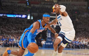 Oklahoma City Thunder guard Shai Gilgeous-Alexander (2) drives around Timberwolves forward Jaden McDaniels (3) in the first quarter.