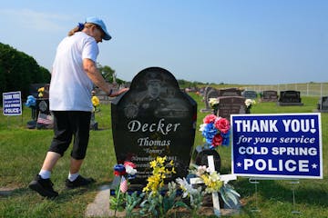 Rosella Decker, the mother of Tommy Decker, who was shot to death while working as a Cold Spring police officer in November 2012, put a hand on his gr