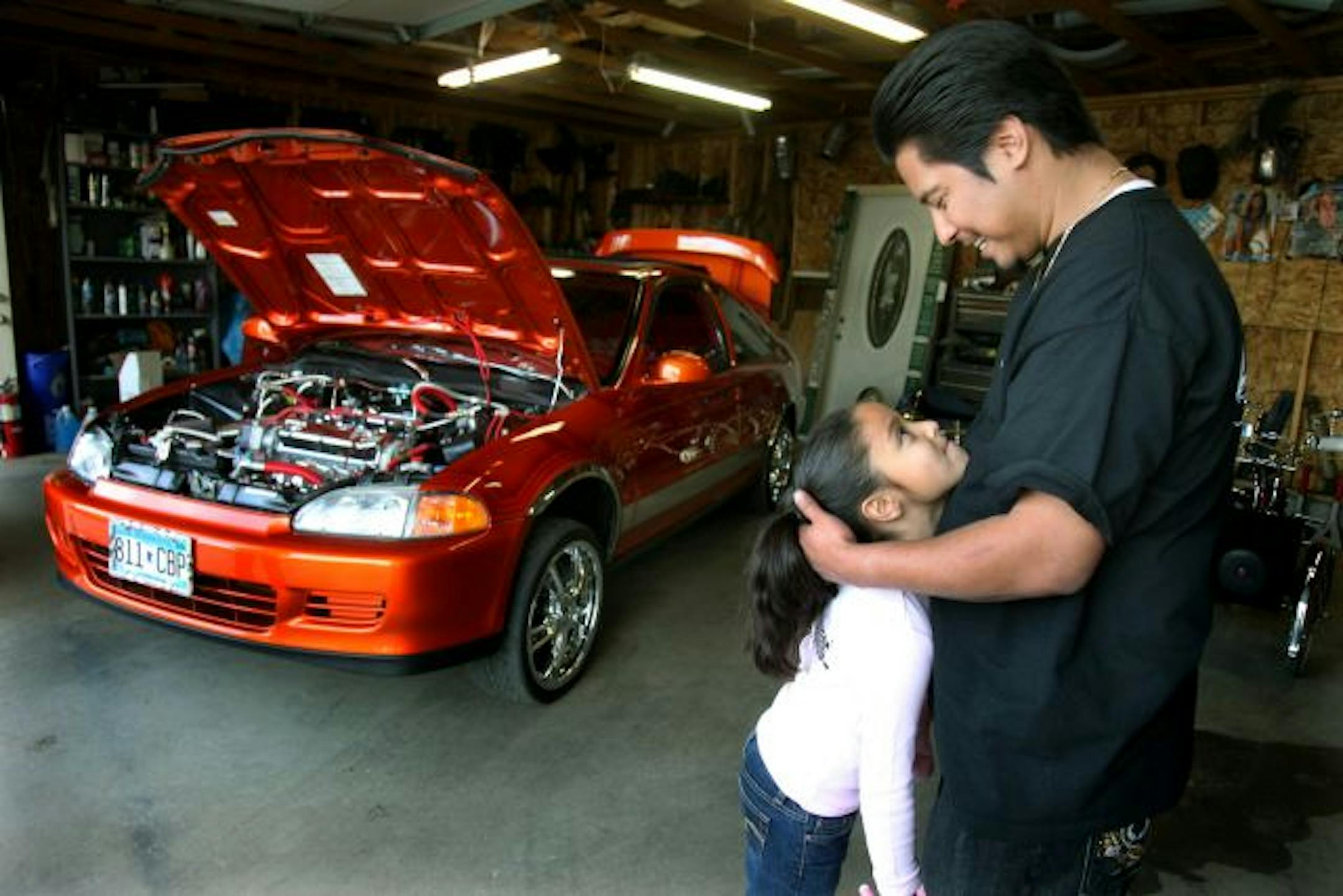 Steve Macias and his daughter Karon can tell you that love of lowriders often runs in the family. The beauty in the back is Carlos Gamboa's lowriding Honda Civic.
