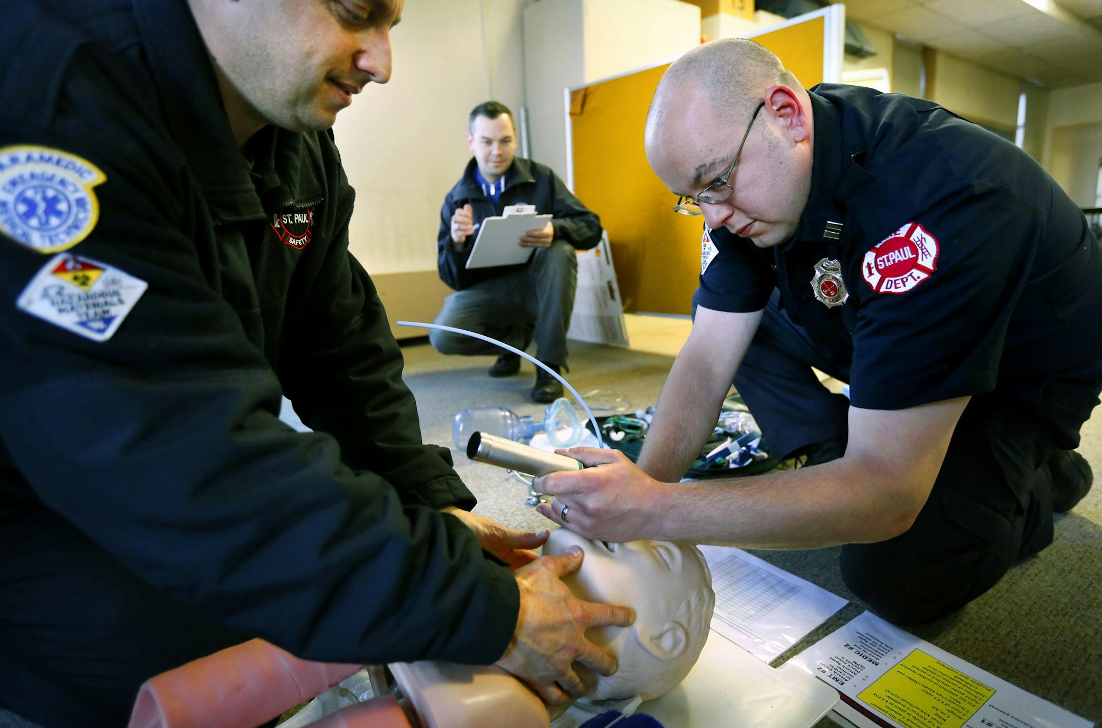St. Paul firefighter paramedics Mark Sottile (left) and Luke Ritchie (right), practice rapid sequence intubation while being observed by Aaron Burnett, MD. Assistant Medical Director at Regions Hospital EMS. (center) ] St. Paul, MN - 11/26//2013