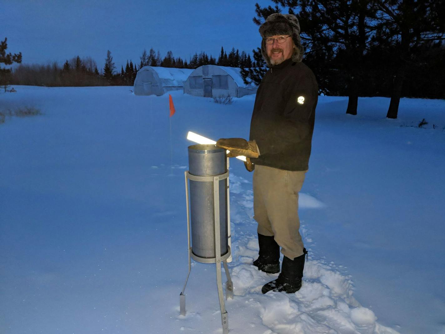 Weather observer Jack La Mar checks the National Weather Service equipment in his back yard on a brisk 21-below morning in Embarrass, Minn.